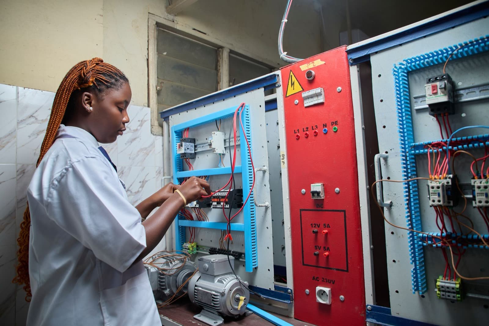 A student working on an electrical wiring board.
